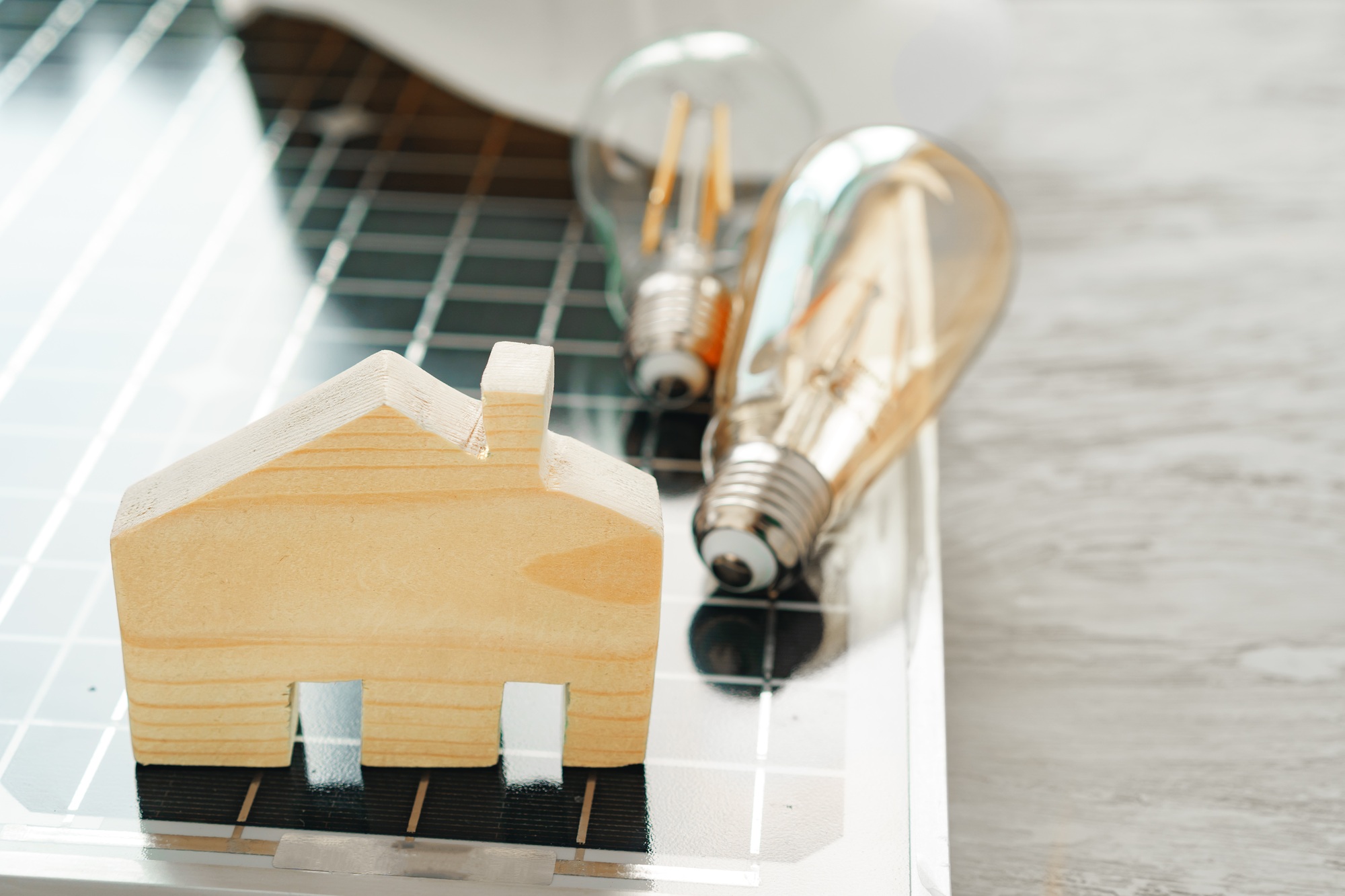 Wooden house miniature and solar panel close up